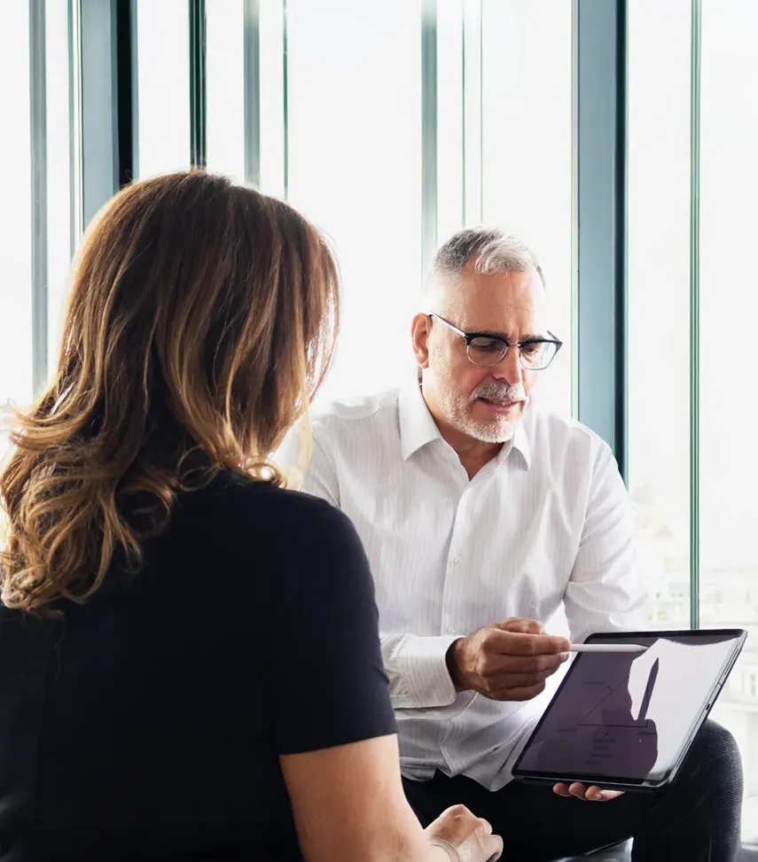 Stefan Reuter berät eine Kundin zu einer bestimmten Kapitalanlage
